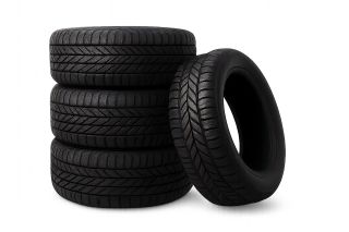 Stack of car tires with one tire leaning against it isolated on transparent background